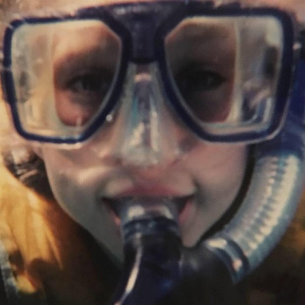 Susannah close to the camera in a snorkel mask and snorkel, in bright sun.